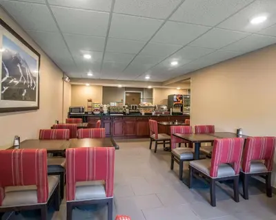 a restaurant with tables and chairs and a kitchen at Comfort Inn Saugerties in Saugerties