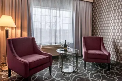 a room with two chairs and a table and a window at Park Manor Hotel in Clifton Park