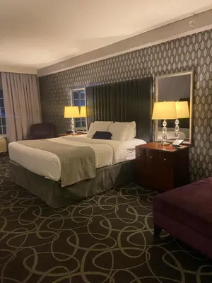 a hotel room with a large bed and two lamps at Park Manor Hotel in Clifton Park