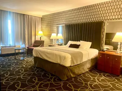 a hotel room with a large bed and a chair at Park Manor Hotel in Clifton Park