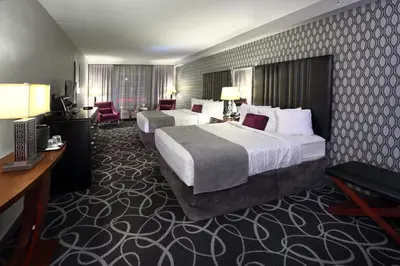 a hotel room with two beds and a desk at Park Manor Hotel in Clifton Park