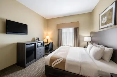 a hotel room with a bed and a flat screen tv at Quality Inn & Suites Fishkill South near I-84 in Fishkill