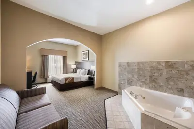 a hotel room with a bed and a tub at Quality Inn & Suites Fishkill South near I-84 in Fishkill