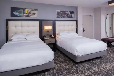 a hotel room with two beds and a table with a lamp at DoubleTree by Hilton Utica in Utica