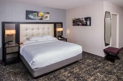 a bedroom with a large white bed and a mirror at DoubleTree by Hilton Utica in Utica