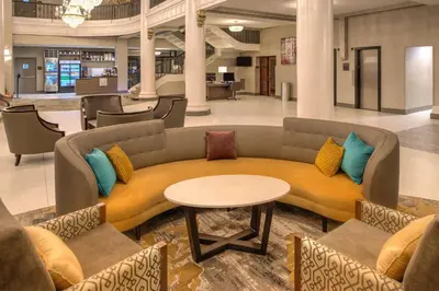 a lobby with a couch and a table and chairs at DoubleTree by Hilton Utica in Utica
