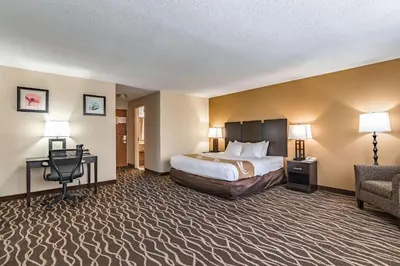a hotel room with a bed and a chair at Quality Inn Schenectady - Albany in Schenectady