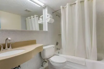 a bathroom with a toilet and a sink and a shower at Rodeway Inn & Suites New Paltz - Hudson Valley in New Paltz