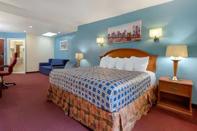 a hotel room with a bed and a blue wall at Rodeway Inn & Suites New Paltz - Hudson Valley in New Paltz
