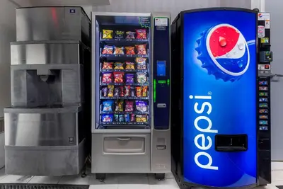 a soda vending machine next to a drink cooler at Rodeway Inn & Suites New Paltz - Hudson Valley in New Paltz
