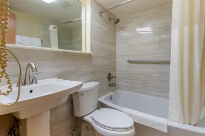 a bathroom with a toilet and a sink and a tub at Rodeway Inn & Suites New Paltz - Hudson Valley in New Paltz