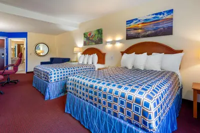 a hotel room with two beds and a desk at Rodeway Inn & Suites New Paltz - Hudson Valley in New Paltz