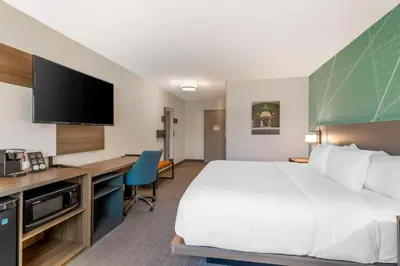 a hotel room with a large bed and a desk at Comfort Inn & Suites Saratoga Springs in Saratoga Springs