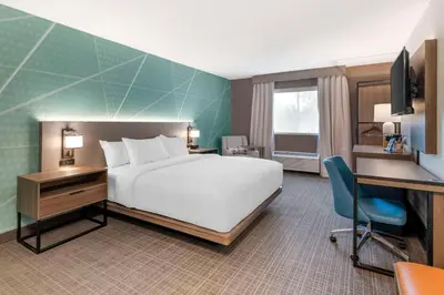 a hotel room with a bed and a desk and a computer at Comfort Inn & Suites Saratoga Springs in Saratoga Springs