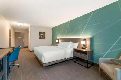a hotel room with a bed and a desk and a chair at Comfort Inn & Suites Saratoga Springs in Saratoga Springs