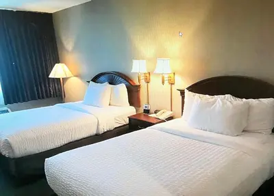 a hotel room with two beds and a phone at The Marx Hotel - Downtown - University Area in Oneonta