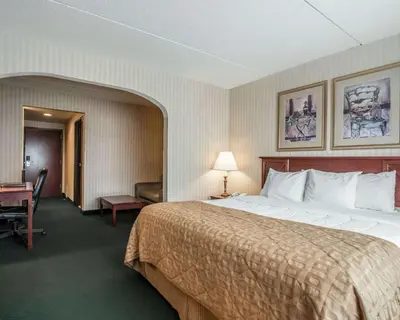 a hotel room with a large bed and a desk at The Marx Hotel - Downtown - University Area in Oneonta
