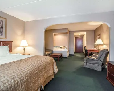 a hotel room with a bed and a chair and a bedroom at The Marx Hotel - Downtown - University Area in Oneonta