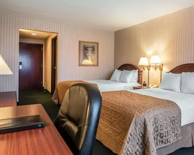 a hotel room with two beds and a desk at The Marx Hotel - Downtown - University Area in Oneonta