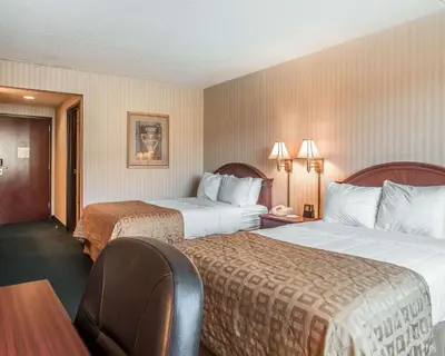 a hotel room with two beds and a table and chairs at The Marx Hotel - Downtown - University Area in Oneonta