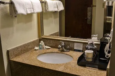 a bathroom counter with a sink and a mirror at Comfort Inn Dunmore - Scranton East in Dunmore