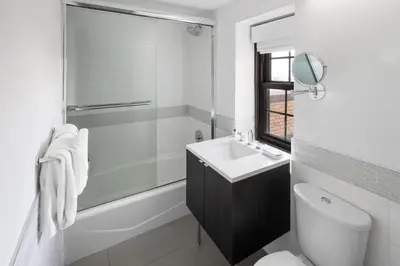 a white bathroom with a sink and a toilet at The Beekman Tower, Trademark Collection by Wyndham in New York