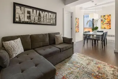 a living room with a couch and a dining room at The Beekman Tower, Trademark Collection by Wyndham in New York