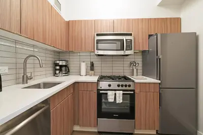 a kitchen with a stove and a microwave at The Beekman Tower, Trademark Collection by Wyndham in New York