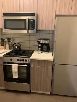 a kitchen with a stove and a microwave and a refrigerator at The Beekman Tower, Trademark Collection by Wyndham in New York