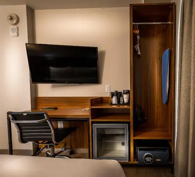 a bedroom with a desk with a television and a chair at La Quinta by Wyndham Time Square South in New York