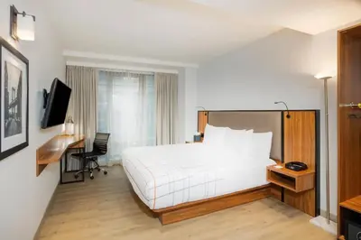 a hotel room with a white bed and a desk at La Quinta by Wyndham Time Square South in New York