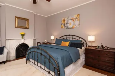 a bedroom with a bed and a fireplace at Rosemont Inn in Utica