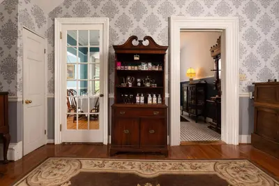 a room with a book shelf with alcohol bottles at Rosemont Inn in Utica