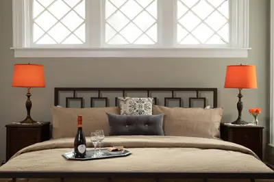 a bed with a tray of food and a bottle of wine at Rosemont Inn in Utica