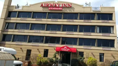 an apartment building with anagency sign on top of it at Airway Inn in Queens