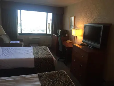 a hotel room with two beds and a flat screen tv at Airway Inn in Queens