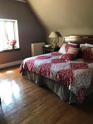 a bedroom with a bed with a red and white comforter at The Castle at Skylands Manor in Ringwood
