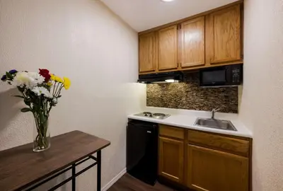 a small kitchen with a vase of flowers on a table at SureStay Plus by Best Western Woodbury Inn in Woodbury