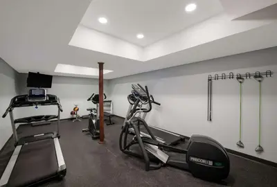 a gym with several tread machines in a room at SureStay Plus by Best Western Woodbury Inn in Woodbury