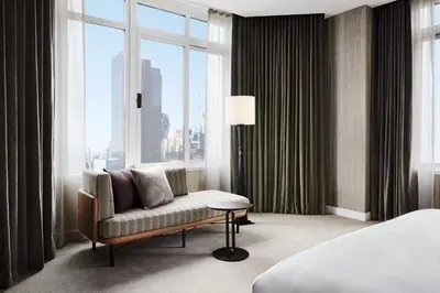a hotel room with a chair and a large window at The Luxury Collection Hotel Manhattan Midtown in New York