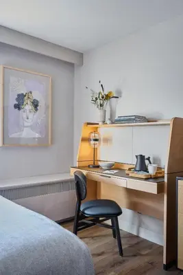 a bedroom with a desk and a bed and a chair at The Watershed Norwalk in Norwalk