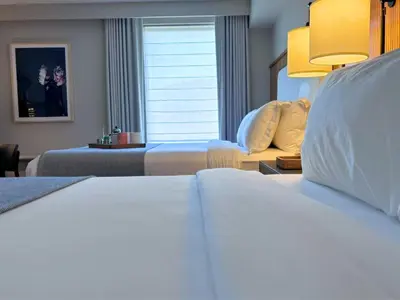 a hotel room with two beds and a couch at The Watershed Norwalk in Norwalk