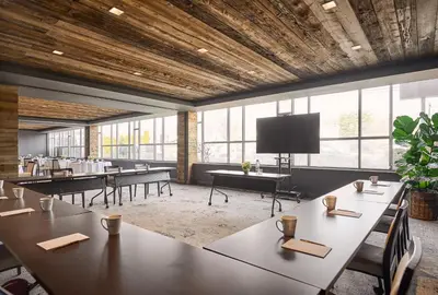 a conference room with tables and a flat screen tv at The Watershed Norwalk in Norwalk
