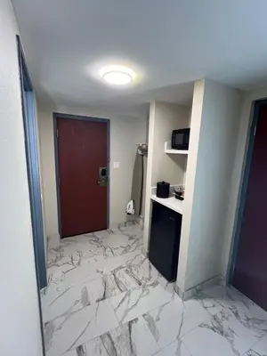 a hotel room with a marble floor and a red door at Rodeway Inn Little Falls in Little Falls