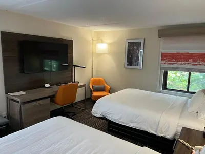 a hotel room with two beds and a desk at Rodeway Inn Little Falls in Little Falls