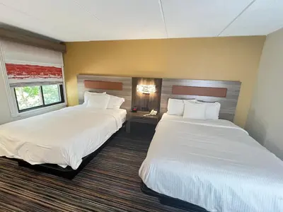 two beds in a hotel room with white sheets at Rodeway Inn Little Falls in Little Falls