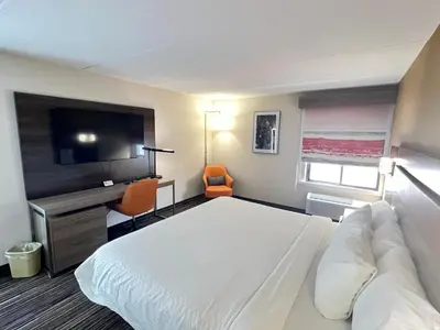 a hotel room with a bed and a flat screen tv at Rodeway Inn Little Falls in Little Falls