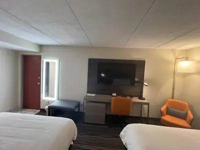 a hotel room with two beds and a flat screen tv at Rodeway Inn Little Falls in Little Falls