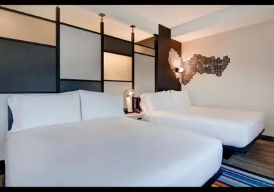 two beds in a room with white sheets at Aloft Secaucus Meadowlands in Secaucus
