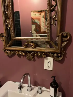 a mirror above a sink in a bathroom at Soul Food 'Mont Morris' in New York